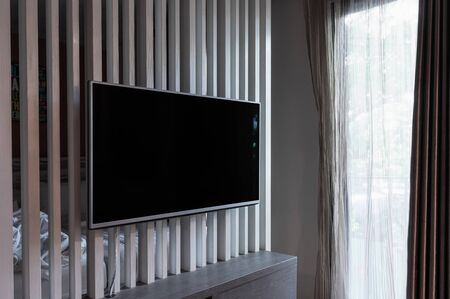 Smart TV on interior partition, blank black screen. Side viewの写真素材
