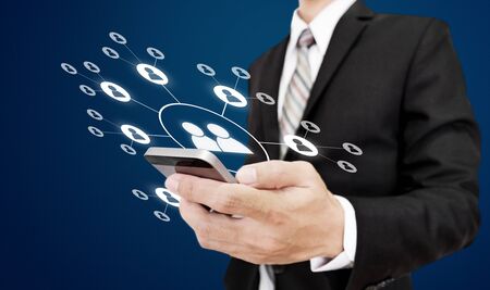 Businessman holding mobile smart phone with social networking iconsの写真素材