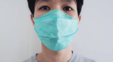 Close-up a man wearing protective face mask. Prevention from Corona virus, bacteria and air pollution dustの写真素材