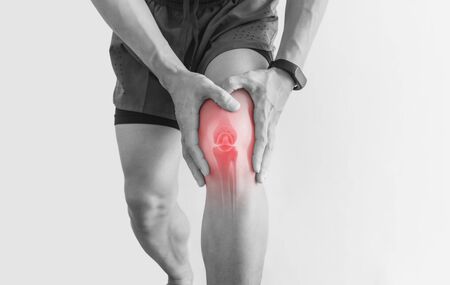 Joint pain, Arthritis and tendon problems. a man touching nee at pain point, on white backgroundの写真素材