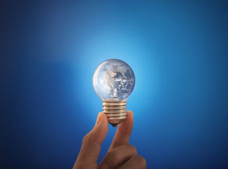 Hand holding glowing  light bulb.