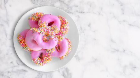Top view, pink donuts in white dish on white marble stoneの写真素材