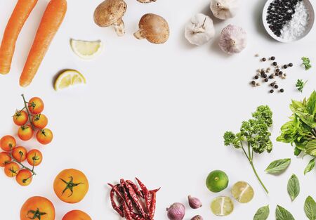 Healthy food ingredient background. Organic vegetables with herbs and spices, on white background with center copy spaceの写真素材