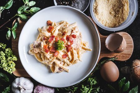 Pasta Carbonara in white dish, surround fresh ingredientの写真素材