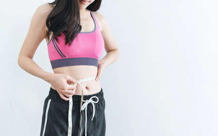 Dieting and weight loss concept, Woman with slim and healthy body using measurement tape