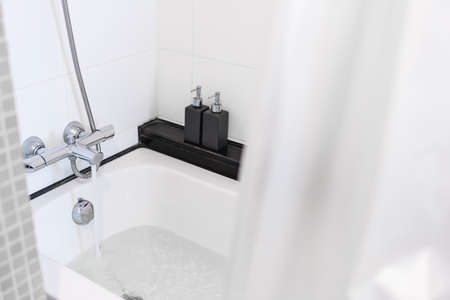 Close-up bath tub with opening water from faucetの写真素材