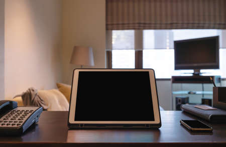 Digital tablet, blank black screen on working tableの写真素材