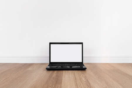Computer laptop, blank white screen, on wood floorの写真素材