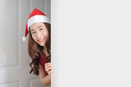 Asian woman wearing santa hat and red dress, with smiling faceの写真素材