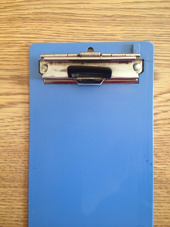 Blue clipboard on wooden tableの素材