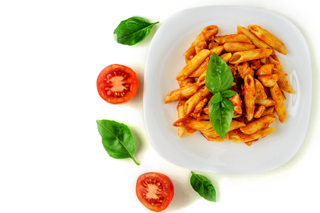 Penne pasta with bolognese sauce, tomato and basil on plate isolatedの写真素材