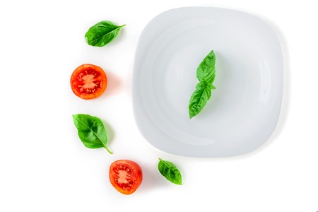 the concept of healthy and proper nutrition. Tomato, basil on white background isolatedの写真素材