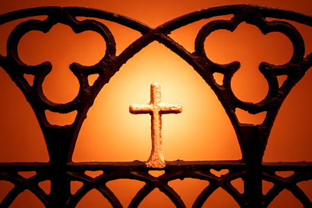 Figure of a cross on an orange background. Christian cross silhouette.の写真素材