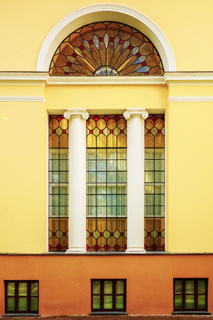 The facade of an ancient building with stained-glass windows and columns. Architectureの写真素材