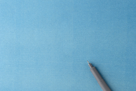 gray pen on a blue blank sheet of paperの写真素材