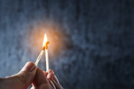 One match sets the other on fire. Fire from matches on a dark blue background. The concept of support, leadership. Photo with copy space.
の写真素材