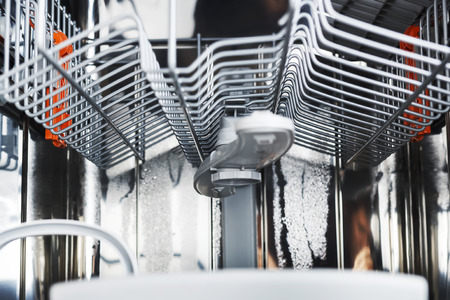 Dishwasher mana machine after washing dishes from the inside. Upper carriage and basket of dishwasherの写真素材