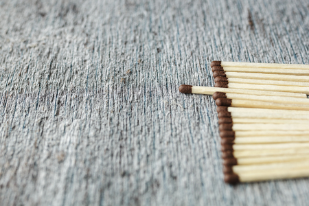 a row of matches against a gray background, one match is pushed forward. Copy spaceの写真素材