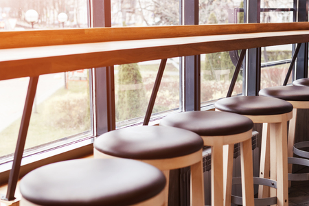 a row of chairs and a bar near the window. Interior cafe. Toned photoの写真素材