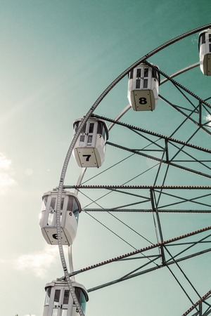 Closed cabs of a Ferris wheel against the sky. Vintage toned photoの写真素材