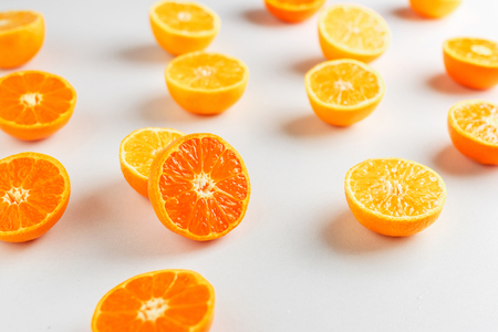 half of mandarins lie on white background. Pattern of mandarinsの写真素材