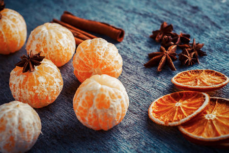 mandarins without peel, anise, cinnamon sticks and orange slices leat on a blue wooden backgroundの写真素材