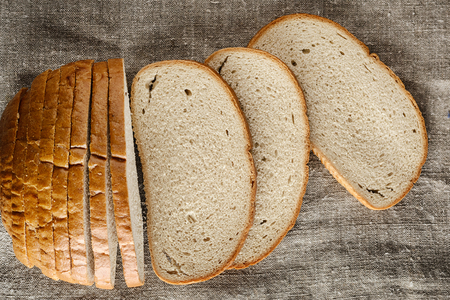 Bread, cut into slices, lies on sackclothの写真素材