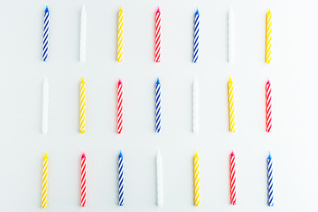 pattern from colored festive candles for a cake on a white background.の写真素材