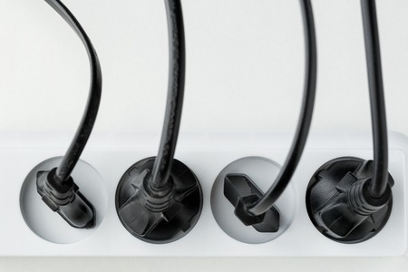 a lot of plugs connected in an extension cord on a white background. Distribution of energy. power supply of electrical appliances from electrical networkの写真素材