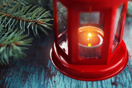 red lantern with a burning candle inside and a Christmas tree brの写真素材