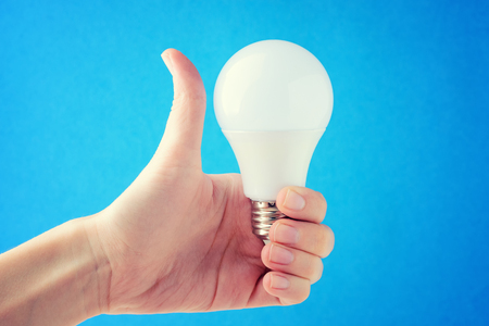 the woman is holding a light bulb in her hands and showing the lの写真素材