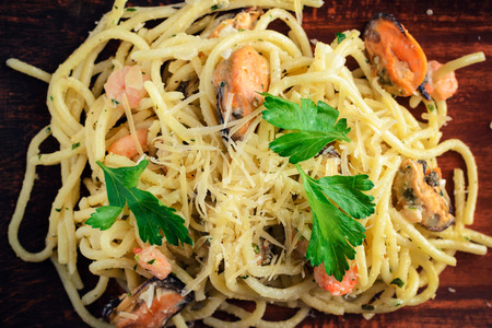 pasta with seafood, prawns and mussels, sprinkled with leaves of parsley and parmesan cheese. Traditional italian cuisineTop viewの写真素材