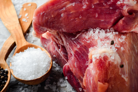 A large piece of fresh juicy meat sprinkled with salt. Preparation of meat for frying steaks.の写真素材