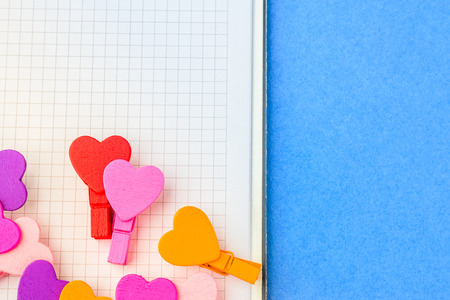A loving couple of little hearts on white paper on a blue background. The concept of a note for Valentine's Dayの写真素材