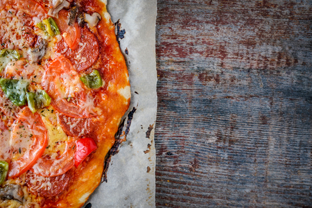 Homemade Italian pizza with salami and parmesan on a wooden background with copy space. Italian Cuisine. Top viewの写真素材