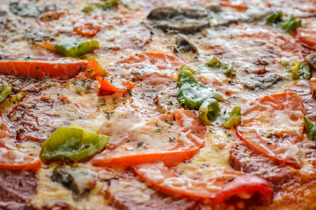 Pizza with salami, tomatoes, pepper and mushrooms as a background. Filled with pizza frame. Top viewの写真素材