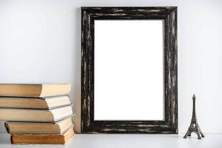 black frame mockup, a place to work. Toy tower and old books near the frame on a white background.の写真素材