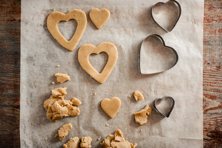The process of making homemade cookies. dough, carved in the form of a heart and cuttings on a wooden table.の写真素材
