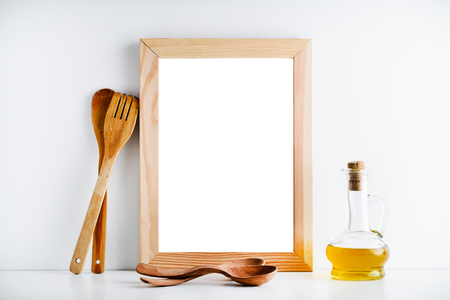 Layout for design. An empty wooden frame and kitchen accessories on a white background.の写真素材