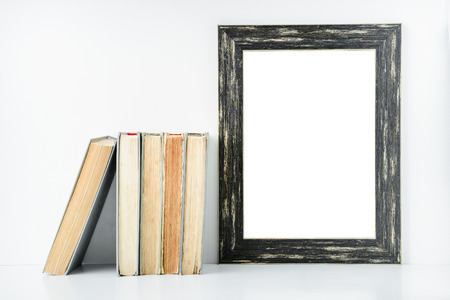 empty black frame and old books on a white background. Layout for designの写真素材