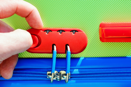 person opens a locking mechanism on the suitcase, access to personal belongings during the trip. The concept of tourist safety while travelingの写真素材