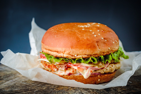 Close-up of delicious fresh home made burger on rustic wooden dark backgroundの写真素材