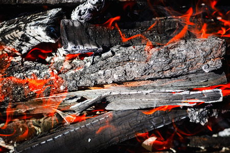 Burning coals, flames in the fire. Background photo with copy space