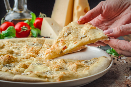 Woman's hands taking slices of pizza, closeup photoの写真素材