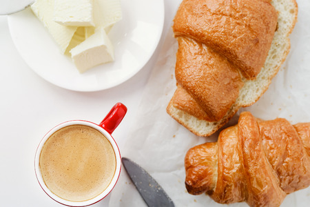 breakfast with cup of coffee and croissants with butter on tableの写真素材