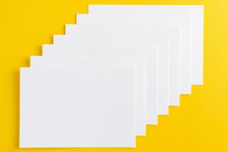 Mockup of white business cards stacked in row on yellow backgroundの写真素材
