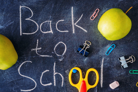 chalkboard with the inscription "back to school", apples and  stationary close-up, top viewの写真素材