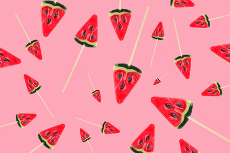 different sweets in form of slices of watermelon without shadows on pink background top view flat lay. Candy pattern similarの写真素材