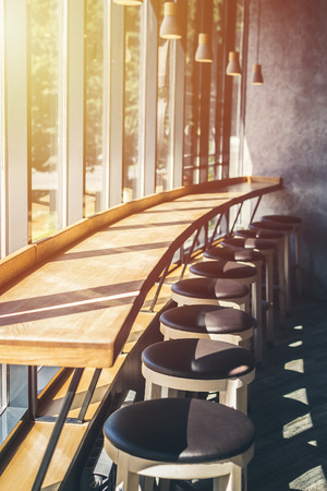 interior cafe. Bar chairs stand in row near large windowの写真素材