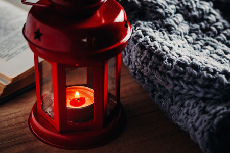 woolen sweater and lantern with candle. Cozy autumn and winter conceptの写真素材
